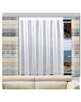 Ein beiges Sofa steht vor einem großen Fenster mit weißen Vorhängen. Das Fenster wird von gemusterten Vorhängen in neutralen Farbtönen eingerahmt. Durch das Fenster sind das Meer, eine felsige Küste und ein blauer Himmel zu sehen.