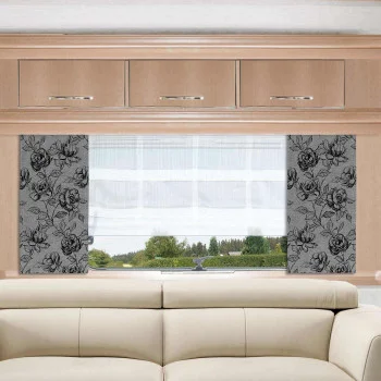 Ein beigefarbenes Sofa steht vor einem Fenster mit weißen Vorhängen und grauen Seitenteilen mit floralem Muster. Drei helle Holzschränke mit silbernen Griffen sind über dem Fenster angebracht. Der Blick nach draußen zeigt grüne Bäume und den Himmel.