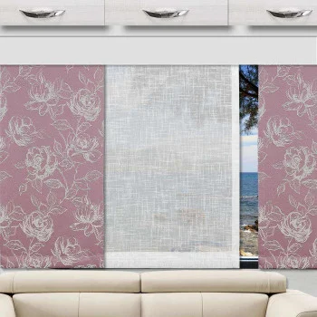 In einem Caravan steht ein beigefarbenes Sofa unter drei Stoffvorhängen. Die äußeren Paneele sind rosa mit weißen Blumenmustern, während das mittlere Paneel durchsichtig weiß ist und einen Teil einer Küstenlandschaft mit blauem Wasser, Bäumen und Himmel durch das Fenster hindurch sichtbar macht.
