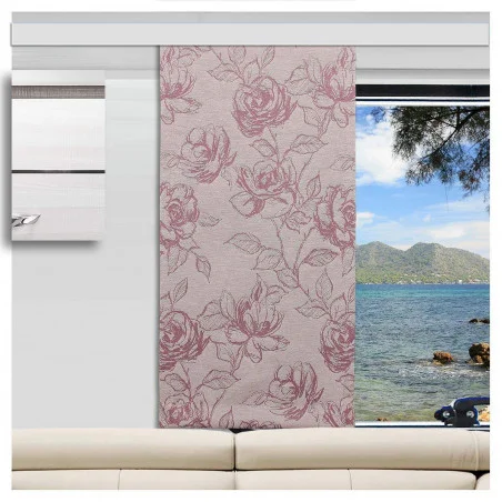 Ein Wohnmobil mit einem beigen Sofa vor einem großen Fenster. Vor dem Fenster ist ein rosafarbener, geblümter Vorhang teilweise zugezogen, der einen Blick auf blaues Wasser, felsige Küste, Baumzweige und ferne grüne Hügel unter einem klaren Himmel freigibt.
