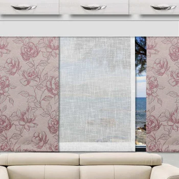 Ein Innenblick eines Wohnmobils mit einem beigen Sofa vor drei Schiebegardinen: zwei mit rosafarbenen Blumenmustern auf jeder Seite und ein durchsichtiges weißes Fenster in der Mitte. Außerhalb des Fensters sieht man das Meer und einen Teil eines Baumes.