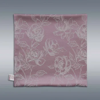 Eine quadratische, hellrosa Kissenhülle 40x40 cm mit einem verschlungenen weißen Blumenmuster aus Rosen und Blättern ist flach vor einem grauen Hintergrund mit Farbverlauf abgebildet. Ein kleines weißes Etikett ist am unteren linken Rand der Hülle angebracht.