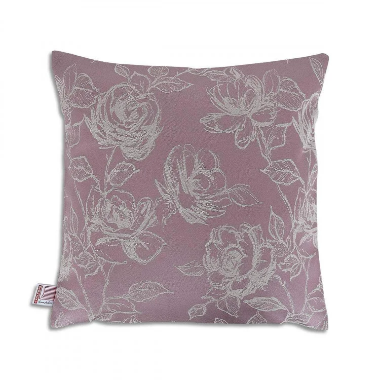 Ein quadratisches Kissen 40x40 cm mit einem gedämpften malvenfarbenen Hintergrund zeigt ein detailliertes weißes Blumenmuster aus Rosen und Blättern. An der unteren linken Seitennaht ist ein Stoffanhänger angebracht. Die Oberfläche des Kissens erscheint weich und ist für den dekorativen Gebrauch bestimmt.