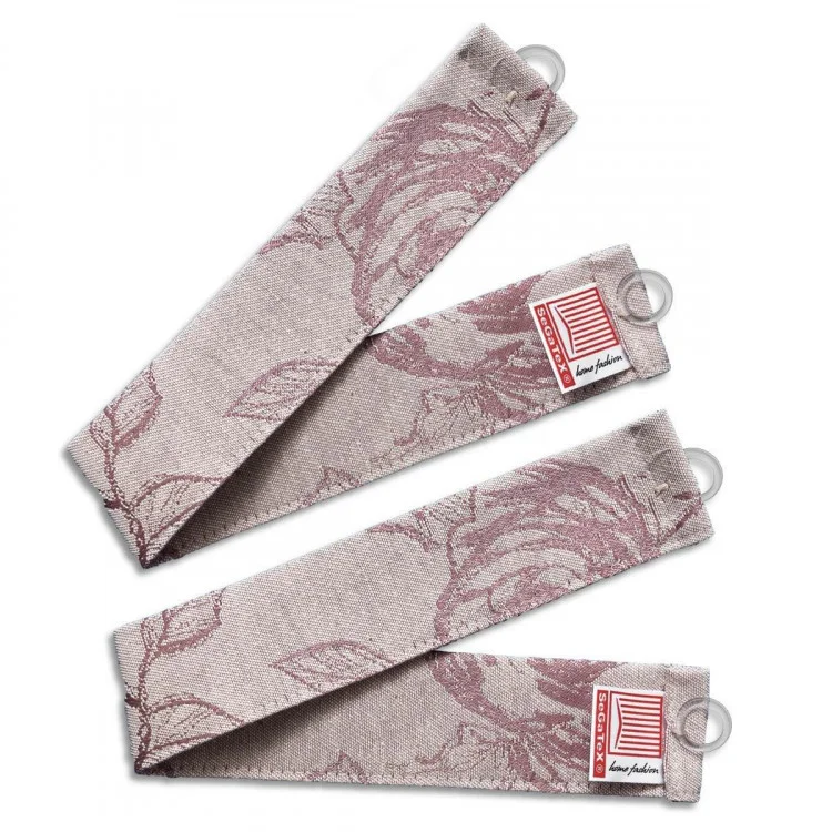 Zwei Raffhalter zeigen ein gedämpftes rosa Blumenmuster auf hellbeigem Hintergrund. Jedes Band hat ein kleines Etikett mit Text und einem rosa Streifenmuster. An einem Ende jedes Riemens sind transparente Ringe angebracht. Der Stoff ist strukturiert und gewebt.
