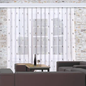 Gardinenstore Astrid mit Scherli-Muster dekoriert an einem modernen Wohnzimmer-Fenster mit großem Sofa im Vordergrund