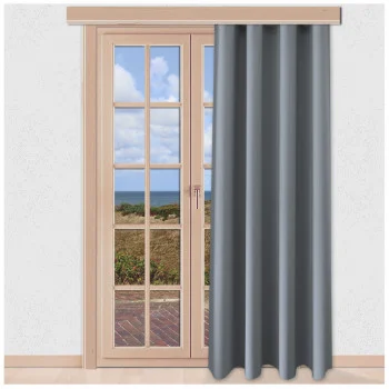 Ein grauer Vorhang bedeckt teilweise eine Glastür mit Holzrahmen. Die Tür öffnet sich zu einer Terrasse mit Ausblick