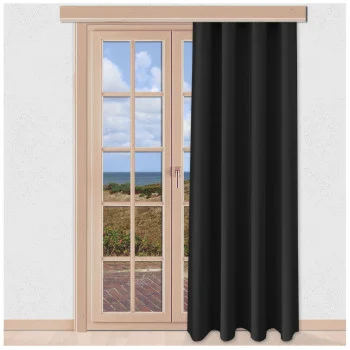 Ein schwarzer Vorhang bedeckt teilweise eine Glastür mit Holzrahmen. Die Tür öffnet sich zu einer Terrasse mit Ausblick