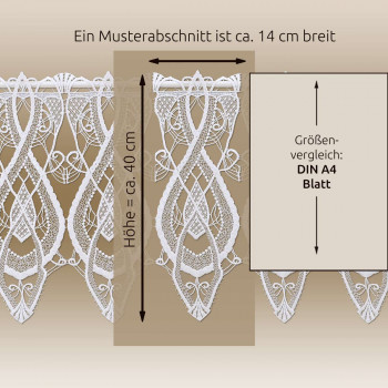 Auf einem beigen Hintergrund ist ein Stück weiße Spitze mit einer Breite von ca. 14 cm und einer Höhe von ca. 40 cm angebracht. Rechts daneben befindet sich ein DIN-A4-Blatt mit den in Deutschland angegebenen Maßen zum Größenvergleich.