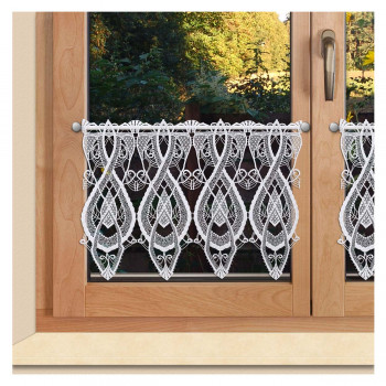 Ein holzgerahmtes Fenster mit zwei Glasscheiben ist mit einem kurzen weißen Spitzenvorhang mit einem komplizierten, symmetrischen Muster versehen. Eine silberne Gardinenstange hält den Vorhang. Durch das Glas sind grüne Bäume zu sehen.