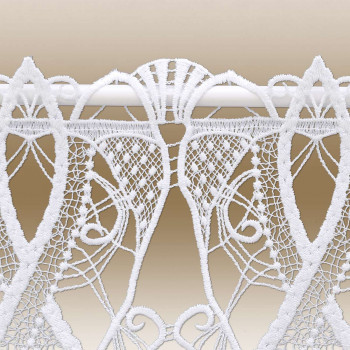 Weiße Spitze mit geometrischen und floralen Mustern hängt an einer Stange vor einem beigen Hintergrund. Die Spitze besteht aus verflochtenen Linien, Blattformen und feinen Netzelementen, die eine detaillierte handwerkliche Verarbeitung der Muster zeigen.