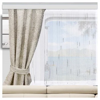 Seitenansicht eines cremefarbenen Sofas neben einem Fenster, auf dem die „Caravan Schiebegardine Alva“-Vorhänge in Weiß-Anthrazit zu sehen sind, die das natürliche Licht sanft filtern.