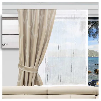 Ein Dekopaneel „Alva“ in Weiß-Anthrazit, angebracht im Innenraum eines Wohnwagens. Links ein Vorhang, der zurückgezogen ist, sodass man durch das Fenster über einem weißen Sofa den Blick auf das Meer genießen kann.