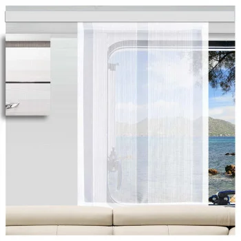 Eine Totale zeigt die SeGaTeX Caravan-Schiebegardine „Lykke“ mit glänzenden Zierstreifen, die vor einem Fenster über einem beigen Sofa hängt und den Blick nach draußen einrahmt.