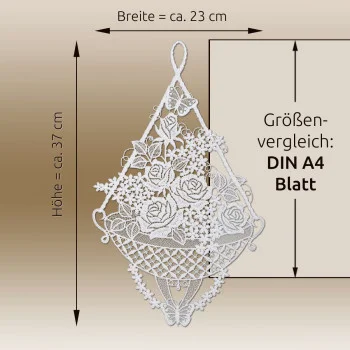 Fensterbild „Rosenkorb Sekt“ von ANDEA design aus Spitze, dargestellt neben einem DIN-A4-Blatt, um die Größe des mit Rosen verzierten Korbmotivs anschaulich zu verdeutlichen.
