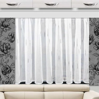Der transparente Vorhang „Alva“ von Caravanstore, hier montiert an einem Wohnwagenfenster, darunter ein beiges Sofa und darüber weiße Schränke mit silbernen Griffen.