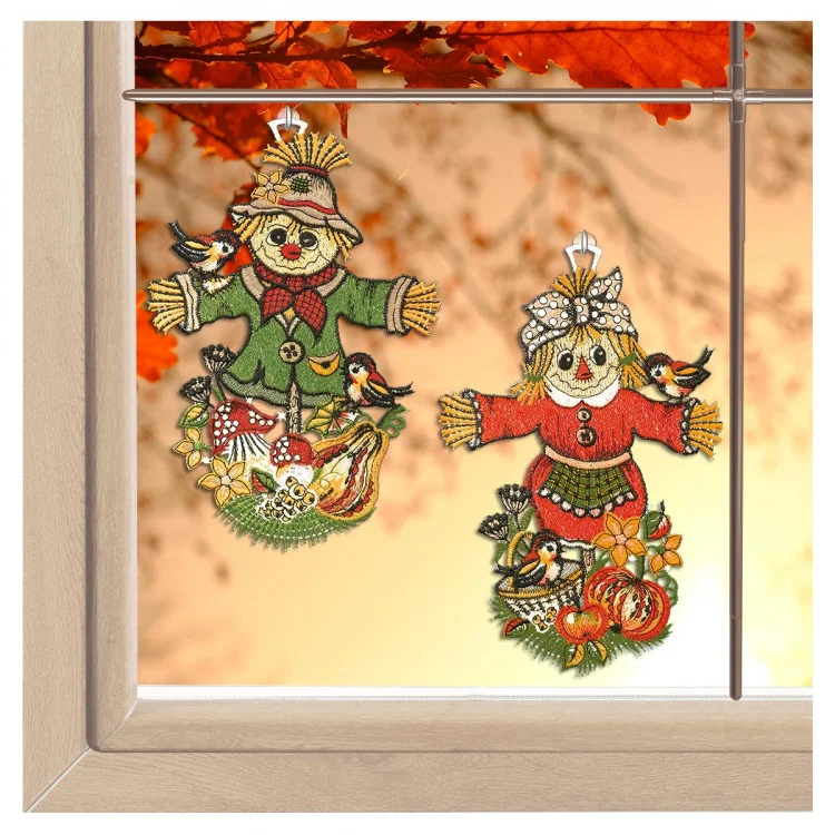 Ein Paar grüner Fensterbehänge mit Vogelscheuchenmotiv von ANDEA design sorgen mit ihrer detailreichen Vogtländischen Spitze für herbstlichen Charme.