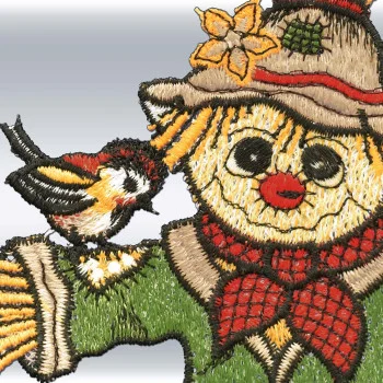 Eine Nahaufnahme des Gesichts der grünen Vogelscheuche zeigt aufwendige Stickereien und ein Detail mit einem darauf sitzenden Vogel aus der Kollektion „Fensterbilder Vogelscheuche Gartenwächter“ von ANDEA Design.