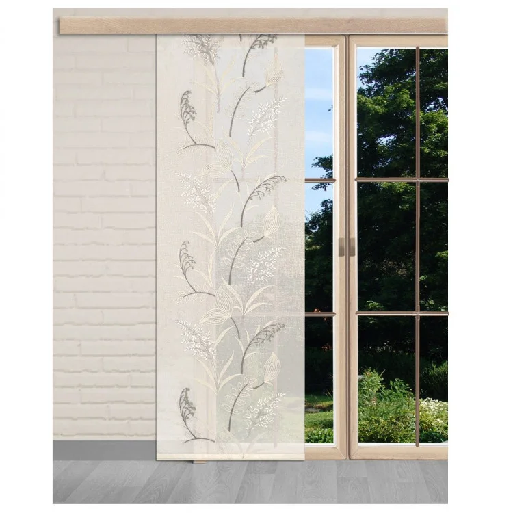 Ein halbtransparenter Vorhang mit einem zarten botanischen Muster hängt vor einem großen Fenster mit einem Holzrahmen, der den Blick auf einen grünen Garten und Bäume freigibt. Der Raum hat weiße Backsteinwände und einen hellgrauen Fußboden.