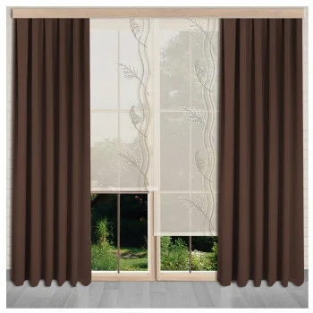 Braune bodenlange Vorhänge umrahmen ein großes Fenster mit zwei cremefarbenen Paneelen, die ein dezentes Blattmuster aufweisen. Draußen sind Grün und Bäume zu sehen. Das Zimmer hat einen hellen Bodenbelag.