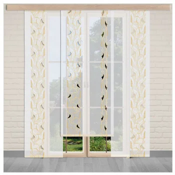 Vor einer Glastür, die den Blick auf eine grüne Außenlandschaft freigibt, hängen weiße Flächengardinen mit Mustern in gelb und beige. Der Raum ist mit hellen Ziegelwänden und grauem Holzboden ausgestattet.