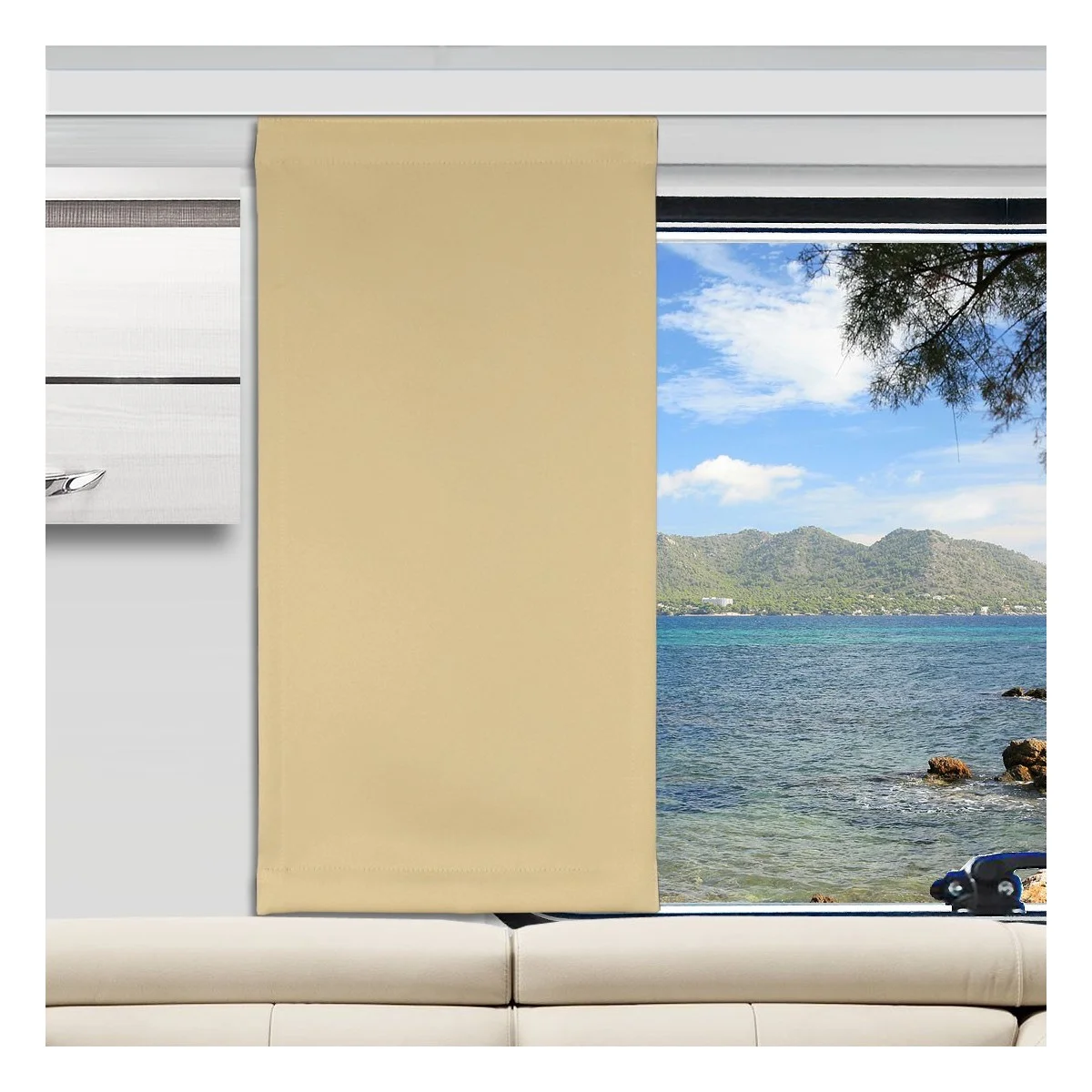Ein beiger Vorhang verdeckt die Hälfte eines großen Fensters. Durch das Glas sind ein blaues Meer, eine felsige Küste, ferne grüne Berge und ein teilweise bewölkter Himmel zu sehen. Im Inneren des Raums steht ein weißes Sofa unterhalb des Fensters, und ein Teil eines weißen Wandregals ist zu sehen.