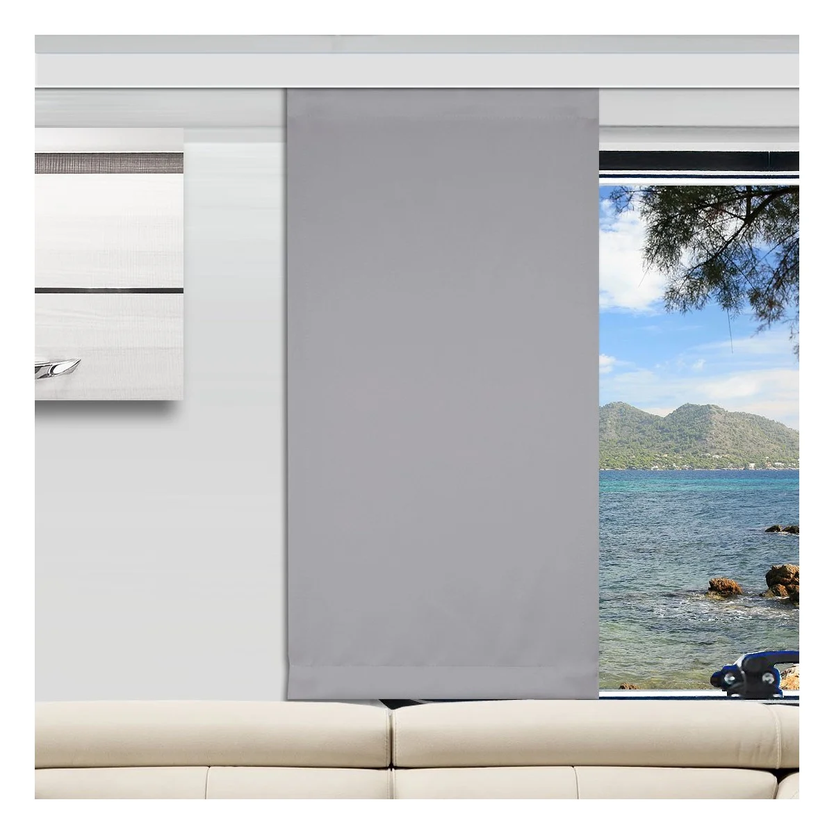 In einem modernen Wohnzimmer ist ein hellgrauer Flächenvorhang teilweise über ein großes Fenster gezogen. Der freigelegte Teil des Fensters zeigt blaues Wasser, eine felsige Küste, grüne Bäume und ferne Berge unter einem hellen Himmel. Davor steht ein beiges Sofa.
