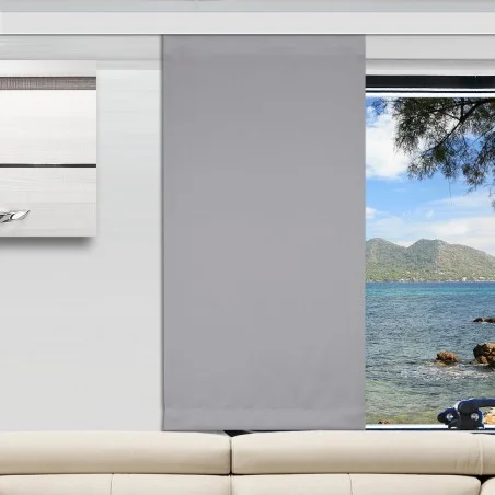 In einem modernen Wohnzimmer ist ein hellgrauer Flächenvorhang teilweise über ein großes Fenster gezogen. Der freigelegte Teil des Fensters zeigt blaues Wasser, eine felsige Küste, grüne Bäume und ferne Berge unter einem hellen Himmel. Davor steht ein beiges Sofa.