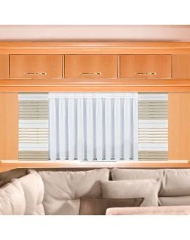 Eine hölzerne Schrankwand mit drei Schubladen ist über einem kleinen Fenster angebracht. Das Fenster hat weiße vertikale Jalousien und helle horizontale Jalousien auf jeder Seite. Davor steht ein teilweise sichtbares beiges Sektionssofa. Der Raum ist in einer neutralen Farbpalette gehalten.