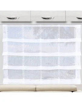 Ein durchsichtiger weißer Vorhang mit horizontalen Streifen ist vor einem großen Fenster angebracht, das viel Licht hereinlässt. Über dem Fenster sind moderne weiße Schränke mit silbernen Griffen angebracht. Ein Teil einer hellen, gepolsterten Bank erscheint am unteren Rand.