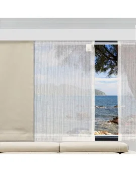 Moderne Caravan-Schiebegardine Mailin vor großen Wohnwagenfenstern. Transparenter weißer Vorhang im Camper mit Ausblick auf das Meer, eine felsige Küste und blauen Himmel.