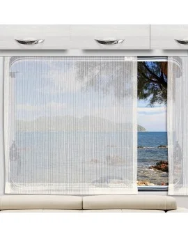 Transparente Caravan-Schiebegardine Mailin Sekt über dem beigen Sofa im Wohnwagen. Lichtdurchlässiger weißer Vorhang am großen Fenster mit Ausblick auf Meer, Hügel und felsige Küste.