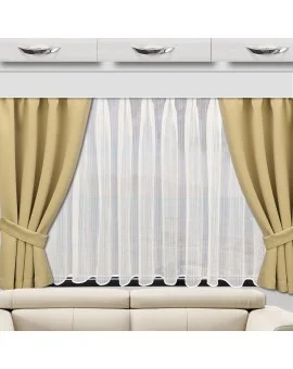 Ein beiges Sofa steht vor einem großen Fenster mit weißen Gardinen und beigen Vorhängen, die an beiden Seiten zurückgebunden sind. Über dem Fenster sind drei weiße Schränke mit silbernen Griffen angebracht, und durch die Vorhänge fällt natürliches Licht.
