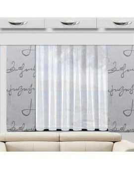 Ein Fenster mit weißen Vorhängen lässt natürliches Licht in den Raum. Die Wand ist mit einer grauen Tapete mit großer schwarzer Kursivschrift bedeckt. Über dem Fenster befinden sich weiße Schränke mit silbernen Griffen. Darunter steht eine beigefarbene Couch mit dunkler Zierleiste. Draußen sind Bäume zu sehen.