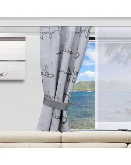 In einem modernen Wohnzimmer steht ein hellbeiges Sofa vor einem Fenster. Ein grauer Vorhang mit schwarzer Schrift ist an einer Seite befestigt und gibt den Blick auf den Ozean mit grünen Hügeln, blauem Himmel und Wolken in der Ferne frei. Daneben hängt ein durchsichtiger weißer Vorhang.