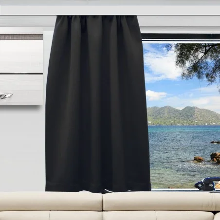 Ein schwarzer Vorhang verdeckt die obere Hälfte eines Fensters, das sich über einem hellbeigen Sofa befindet. Der unbedeckte untere Teil zeigt ein blaues Meer, eine felsige Küste, ferne grüne Berge und einen teilweise bewölkten Himmel.