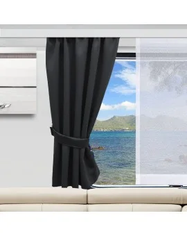 Ein schwarzer Vorhang, der an der Seite befestigt ist, gibt den Blick auf ein Fenster frei, das einen Blick auf ein ruhiges blaues Meer, grüne Hügel und einen teilweise bewölkten Himmel bietet. Ein durchsichtiger weißer Vorhang ist an einer Seite zugezogen. Im Innenraum sind ein Teil eines beigen Sofas und ein moderner Schrank zu sehen.