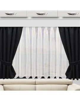 Ein beiges Sofa steht vor einem Fenster mit weißen Vorhängen, die von schwarzen Verdunkelungsvorhängen eingefasst sind. Über dem Fenster befinden sich drei weiße Hängeschränke mit silbernen Griffen. Durch die durchsichtigen Vorhänge fällt sanftes Licht in den Raum.