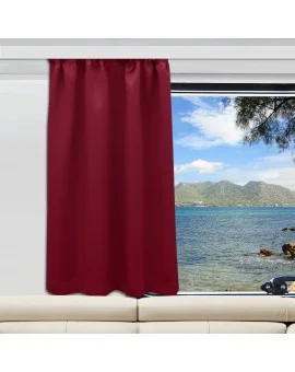 Ein weinroter Vorhang ist auf der linken Seite eines Fensters angebracht, das sich über einem weißen Sofa befindet. Durch das Fenster blickt man auf ein blaues Meer, grüne Hügel und einen teilweise bewölkten Himmel. Auf der rechten Seite des Rahmens ragt ein Baumzweig ins Bild.