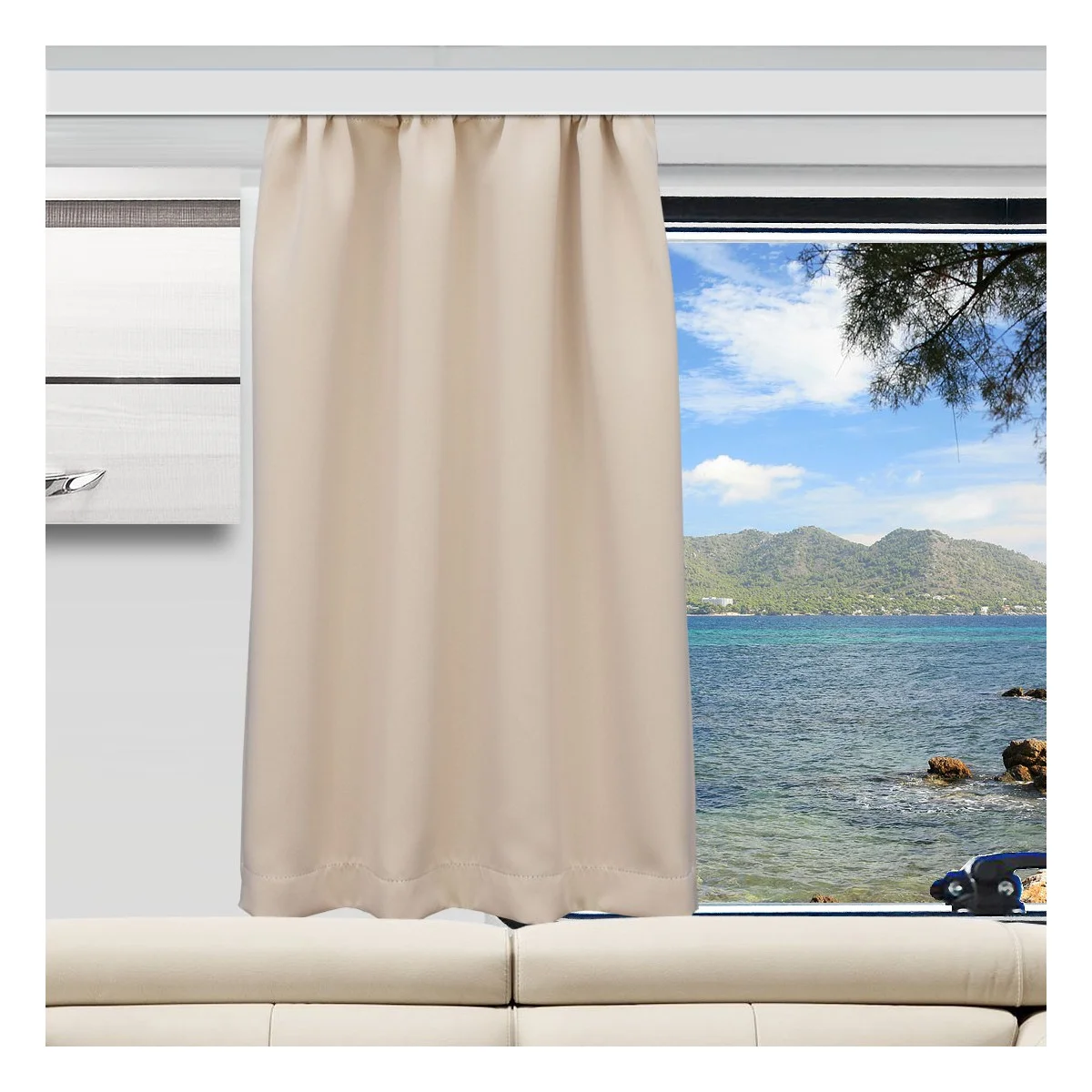 Ein beiger Vorhang verdeckt einen Teil eines großen Fensters. Durch das Fenster sind ein blaues Meer, eine felsige Küste, grüne Hügel und ein teilweise bewölkter Himmel zu sehen. Im Inneren des Raums steht ein weißes Sofa unter dem Fenster, und ein Teil einer an der Wand montierten Klimaanlage ist zu sehen.