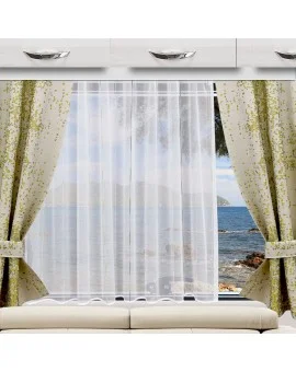 Ein großes Fenster mit weißen Vorhängen und goldgemusterten Gardinen, die zurückgezogen sind, gibt den Blick auf das Meer, die Berge in der Ferne, die Felsen und den blauen Himmel frei. Das Fenster ist von einem weißen Schrank umgeben, unter dem sich eine gepolsterte Bank befindet.