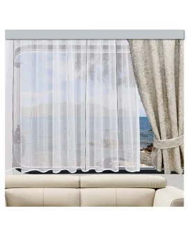 Ein weißer durchsichtiger Vorhang verdeckt ein Fenster mit Blick auf das Meer und die Berge. Auf der rechten Seite ist ein beigefarbener gemusterter Vorhang zurückgebunden. Unterhalb des Fensters ist ein helles Sofa an die Wand gestellt.