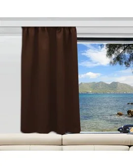 Ein brauner Vorhang ist an einem Fenster, das sich über einem beigen Sofa befindet, teilweise geöffnet. Das Fenster gibt den Blick auf ein blaues Meer, eine felsige Küste, grüne Berge in der Ferne und einen teilweise bewölkten Himmel frei. Von der rechten Seite ragt ein Baumast in die Szene hinein.