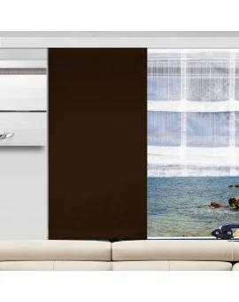 In einem modernen Wohnzimmer steht eine beigefarbene Couch vor einem Fenster mit zwei Paneelen - einem einfarbigen dunkelbraunen und einem durchsichtigen weißen. Das Fenster bietet einen Blick auf blaues Wasser, Felsen und Himmel. An der hellgrauen Wand befinden sich ein schwebendes Regal und ein Schrank.